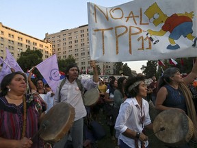 People take part in a demonstration against the Trans-Pacific Partnership, TPP, outside La Moneda presidential palace, in Santiago, Chile, Wednesday, March 7, 2018. Protesters voiced their opposition to the signing of the 11-country pact that includes Peru, Mexico, New Zealand, Canada, Australia, Malaysia, Japan, Singapore, Vietnam, Brunei and Chile.