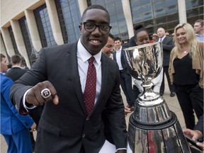 Moton Hopkins displays his Grey Cup ring as he stands beside the CFL championship trophy in May 2017.