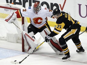 Pittsburgh's Evgeni Malkin (71) gathers the puck and prepares to put it behind Calgary netminder Jon Gillies (32) for a goal in the first period of a game on Monday.