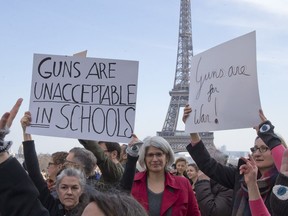 People hold banners during the "March For Our Lives" event in Paris, France, Saturday, March 24, 2018. The march is one of hundreds happening across the U.S. and the world to urge U.S. lawmakers to pass stricter gun safety legislation after deadly school shootings.