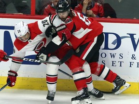 Senators captain Erik Karlsson (65) gets tangled up with the Hurricanes' Sebastian Aho during second-period play at Canadian Tire Centre on Saturday night. THE CANADIAN PRESS/Fred Chartrand