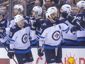 Jets defenceman Dustin Byfuglien (33) skates along the bench as he celebrates with teammates after scoring his team's second goal against the Maple Leafs on Saturday night.