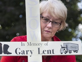 Kathleen Reed with a cross memorializing her partner Gary Lent, who was killed in a 401 collision. Photo shot in London, Ont. on Thursday October 26, 2017. Derek Ruttan/The London Free Press