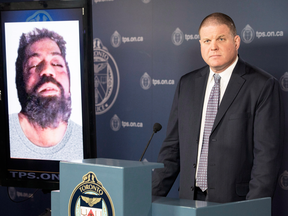 Det. Hank Idsinga, lead investigator in the case against alleged serial killer Bruce McArthur, stands with a photo of an unidentified man, suspected of being another of McArthur's victims, during a news conference on Monday, March 5, 2018.