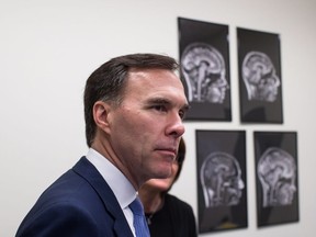 Finance Minister Bill Morneau takes a tour of the Brain Behaviour Laboratory at the University of British Columbia March 6. He and the Liberal government are battling some big political headaches these days.