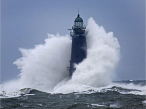 Waves crash against a lighthouse.
