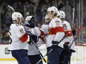 Florida Panthers defenseman Keith Yandle, third from left, celebrates with teammates Aleksander Barkov (16), of Finland, and Evgenii Dadonov (63), of Russia, after scoring a goal against the New York Islanders during the first period of an NHL hockey game in New York, Monday, March 26, 2018.