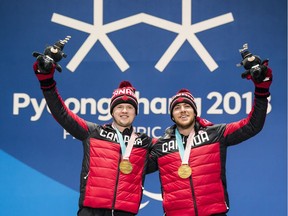Mac Marcoux, right, and his guide Jack Leitch collect their gold medals from the men's visually impaired downhill skiing during the medal ceremony on Saturday.