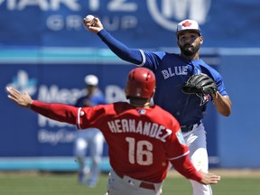 Blue Jays second baseman Devon Travis forces out the Phillies' Cesar Hernandez (16) at second and relays the throw to first base to complete a double play during the fourth inning of a spring training game in Dunedin, Fla., on Wednesday.