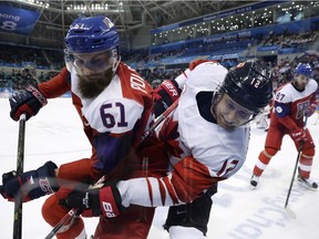 Adam Polasek (61), of the Czech Republic, and Rob Klinkhammer (12), of Canada, battle for the puck during the third period of the men's bronze medal hockey game at the 2018 Winter Olympics in Gangneung, South Korea, Saturday, Feb. 24, 2018.