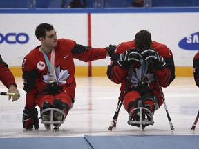 Canada's Dom Cozzolino, left, consoles teammate Bryan Sholomicki after they received their silver medals from losing to the United States in the Ice Hockey gold medal match for the 2018 Winter Paralympics at the Gangneung Hockey Center in Gangneung, South Korea, Sunday, March 18, 2018.