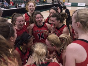 Members of the Carleton Ravens celebrate their gold medal win during the U Sports Women's Basketball final at University of Regina in Regina, Saskatchewan on Sunday March 11, 2018. THE CANADIAN PRESS/Michael Bell