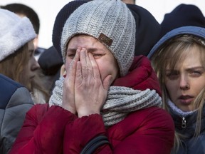 A woman reacts after laying flowers for the victims of a fire in a multi-story shopping center in the Siberian city of Kemerovo, about 3,000 kilometers (1,900 miles) east of Moscow, Russia, Monday, March 26, 2018. Russian officials say a fire at a shopping mall in a Siberian city has killed over 50 people. The Ekho Mosvky radio station quoted witnesses who said the fire alarm did not go off and that the staff in the mall in Kemerovo did not organize the evacuation.