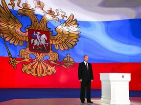 Russian President Vladimir Putin stands after giving his annual state of the nation address in Manezh in Moscow, Russia, Thursday, March 1, 2018. Putin set a slew of ambitious economic goals, vowing to boost living standards, improve health care and education and build modern infrastructure in a state-of-the-nation address.