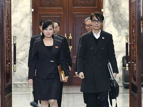 In this photo provided by South Korea Unification Ministry, North Korean Hyon Song Wol, left, head of a North Korean art troupe, walks with her South Korean counterpart Yun Sang to hold a meeting to discuss a South Korean art troupe's planned performance in Pyongyang, North Korea, at the North side of Panmunjom, North Korea, Tuesday, March 20, 2018. (South Korea Unification Ministry via AP)