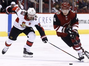 Coyotes forward Max Domi, right, skates past Senators defenceman Erik Karlsson.