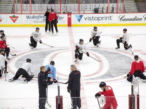 Senators players stretch out in the middle of the ice surface before practice at Canadian Tire Centre on Friday. Wayne Cuddington/ Postmedia