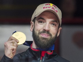 Charles Hamelin holds up his gold medal after winning the 1,500-metre final of the ISU world short-track speed skating championships in Montreal on Saturday.