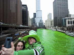 Stacey Peterson and Kevin McGuire take a selfie in front of the green Chicago River to celebrate St. Patrick's Day, Saturday, March 17th, 2018.  The Chicago River has been dyed a bright shade of green, kicking off the city's St. Patrick's Day festivities. Thousands of people lined the riverfront downtown Chicago  to see the dyeing, a tradition for the holiday that dates to 1962.