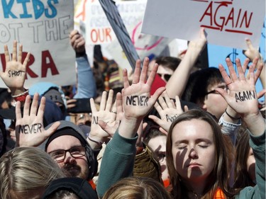 People hold their hands up with messages written on them during the "March for Our Lives" rally in support of gun control, Saturday, March 24, 2018, in Washington.