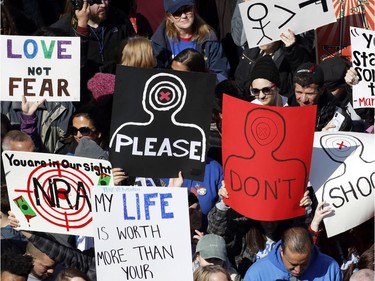 People hold signs during the "March for Our Lives" rally in support of gun control, Saturday, March 24, 2018, in Washington.