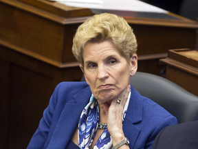 Premier Kathleen Wynne listens to her throne speech being delivered by Ontario Lieutenant Governor Elizabeth Dowdeswell at Queens Park in Toronto, Monday, March 19, 2018.