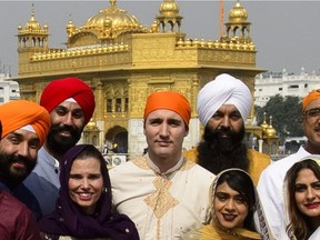 Prime Minister Justin Trudeau, centre, stands beside Surrey Centre MP Randeep Sarai, top centre right, as they join fellow MPs for a group photo while visiting the Golden Temple in Amritsar, India on Wednesday, Feb. 21, 2018.