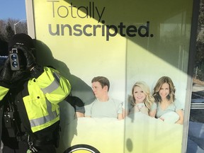 Traffic officer blends in with a Transpo shelter billboard in safety blitz..
