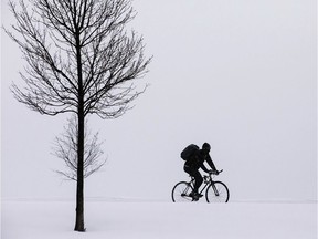 A bicyclist rides in the winter.