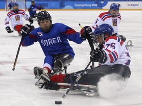 Czech Republic's Jiri Raul keeps the puck from South Korea's Choi Kwang Hyouk during a preliminary Ice Hockey match of the 2018 Winter Paralympics held in Guangneung, South Korea, Sunday, March 11, 2018.