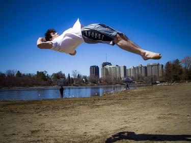 Warmer temperatures hit Ottawa Sunday April 22, 2018 and people were out and about enjoying the sunshine at Mooney's Bay Park. Brandon Azzie working on his parkour tricks on the beach Sunday afternoon in the warm sunshine.