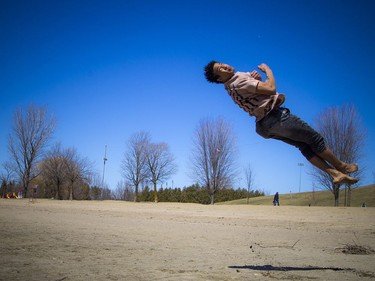 Warmer temperatures hit Ottawa Sunday April 22, 2018 and people were out and about enjoying the sunshine at Mooney's Bay Park. Sheldon Morgan working on his parkour tricks on the beach Sunday afternoon in the warm sunshine.