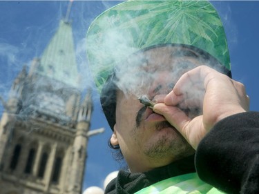 Taryn Morrison hauls on his joint at the rally. It was the annual 4/20 rally on Parliament Hill Friday as hundreds gathered to smoke pot and celebrate cannabis culture.  Organizers of this year's rally say it's a celebration and a protest: a celebration for the forthcoming legalization of pot this summer and a protest of the government's strict regulations surrounding that.  Julie Oliver/Postmedia