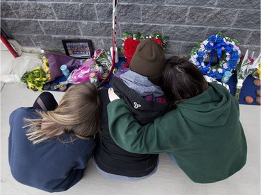 Adriana Martell, Carly Zimmer and Jessica Johnson console each other at a memorial for their friend Stephen Wack outside Athletes Nation One gym, in St. Albert Saturday April 7, 2018.