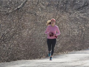 A woman jogs alongside the Queen Elizabeth Driveway in Ottawa on a sunny spring day in Ottawa. April 11,2018.