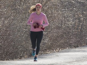 A woman jogs alongside the Queen Elizabeth Driveway in Ottawa.