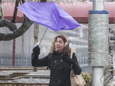 Rachel Hauraney has her umbrella pop as she walks in the wind and rain along Laurier Avenue in Ottawa. April 16,2018.