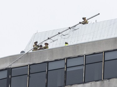 Ottawa firefighters secure a tower that broke atop the Delta Hotel in downtown Ottawa. April 16,2018.