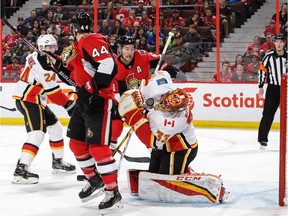 Ottawa alternate captain Mark Stone, middle, watches as a shot bounces off Calgary netminder David Rittich during a March 9 game at Canadian Tire Centre. Stone's leg was injured in that same contest and he hasn't played since.