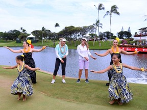 Brooke Henderson of Smiths Falls and her caddie and sister, Brittany Henderson, participate in a hula at the victory ceremony on Saturday.