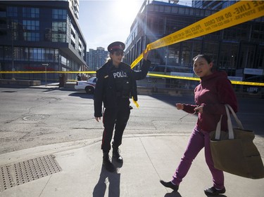 TORONTO, ON - APRIL 23: A police officer lifts caution tape for a pedestrian around the scene on Yonge St. at near Finch Ave., after a van plowed into pedestrians on April 23, 2018 in Toronto, Canada. A suspect identified as Alek Minassian, 25, is in custody after a driver in a white rental van collided with multiple pedestrians killing nine and injuring at least 16.