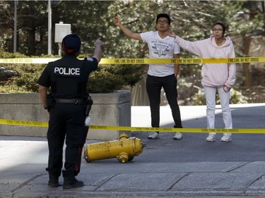 TORONTO, ON - APRIL 23: A police officer speaks with pedestrians trying to cross Yonge St. at near Finch Ave., after a van plowed into pedestrians on April 23, 2018 in Toronto, Canada. A suspect identified as Alek Minassian, 25, is in custody after a driver in a white rental van collided with multiple pedestrians killing nine and injuring at least 16.