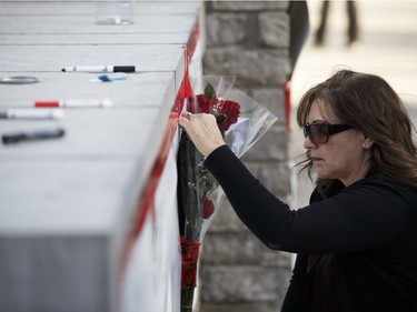 TORONTO, ON - APRIL 23: A woman signs a memorial card for the victims near the scene on Yonge St. at Finch Ave., after a van plowed into pedestrians on April 23, 2018 in Toronto, Canada. A suspect identified as Alek Minassian, 25, is in custody after a driver in a white rental van collided with multiple pedestrians killing nine and injuring at least 16.