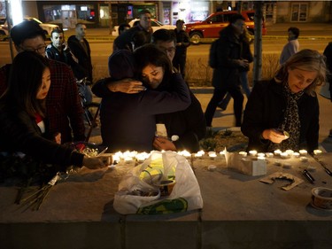 TORONTO, ON - APRIL 23: People embrace as they lay candles and leave messages at a memorial for victims of a crash on Yonge St. at Finch Ave., after a van plowed into pedestrians on April 23, 2018 in Toronto, Canada. A suspect identified as Alek Minassian, 25, is in custody after a driver in a white rental van collided with multiple pedestrians killing nine and injuring at least 16.