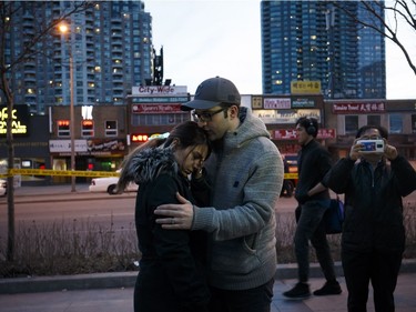 TORONTO, ON - APRIL 23: People embrace at the scene of a memorial for victims of a crash at Yonge St. at Finch Ave., after a van plowed into pedestrians on April 23, 2018 in Toronto, Canada. A suspect identified as Alek Minassian, 25, is in custody after a driver in a white rental van collided with multiple pedestrians killing nine and injuring at least 16.