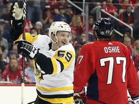 Jake Guentzel (59) of the Pittsburgh Penguins celebrates his game-winning goal against the Washington Capitals with Sidney Crosby at the Capital One Arena on April 26, 2018 in Washington, DC.