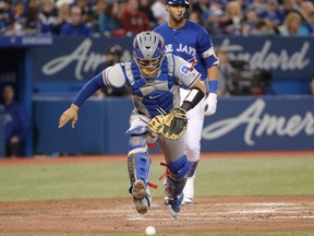 Robinson Chirinos #61 of the Texas Rangers chases the ball that got away on a wild pitch in the fourth inning during MLB game action against the Toronto Blue Jays at Rogers Centre on April 29, 2018 in Toronto.