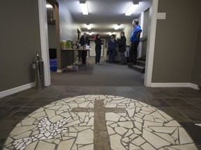 People stand in the entrance to the Nipawin Apostolic Church where families were meeting after a bus carrying the Humboldt Broncos SJHL hockey team crashed on Highway 35 on Friday, April 6, 2018.