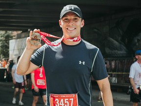 A runner shows off his medal during the Tamarack Ottawa Race Weekend.