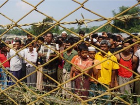 In this file photo taken on March 18, 2018 minority Rohingya Muslims gather behind Myanmar's border lined with barbed wire fences in Maungdaw district, located in Rakhine State bounded by Bangladesh.